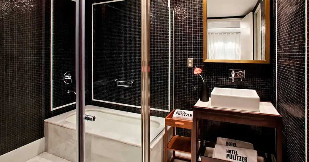 A smartly designed bathroom at Hotel Pulitzer, with dramatic black tile and polished marble for a sophisticated city stay