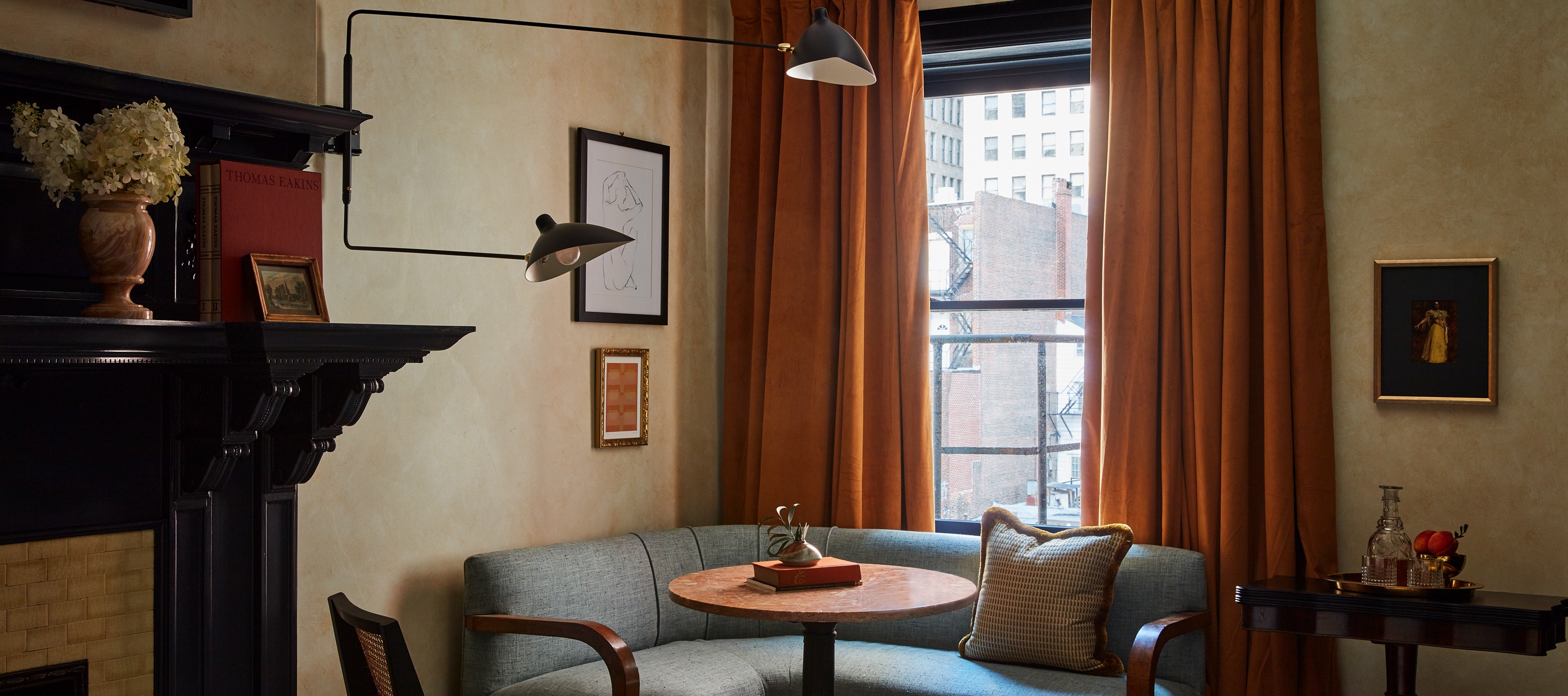 Cozy seating nook with blue banquette and orange window drapes