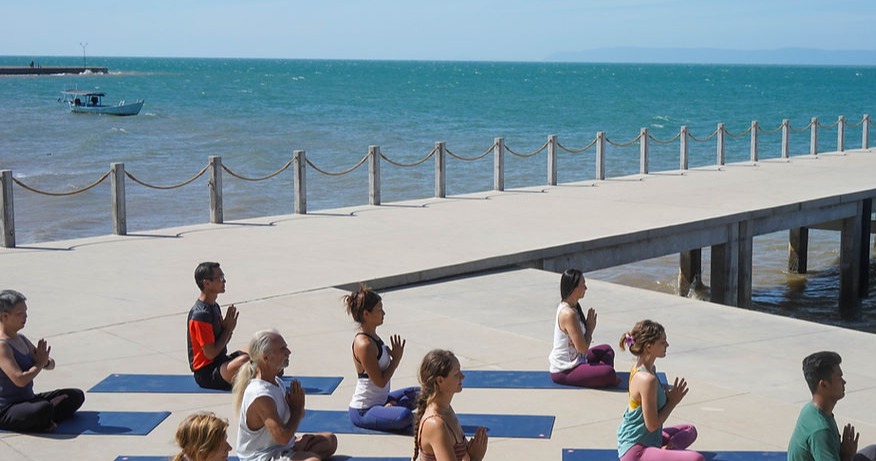 Illuminated beachfront resort villas at night with palm trees and manicured lawn